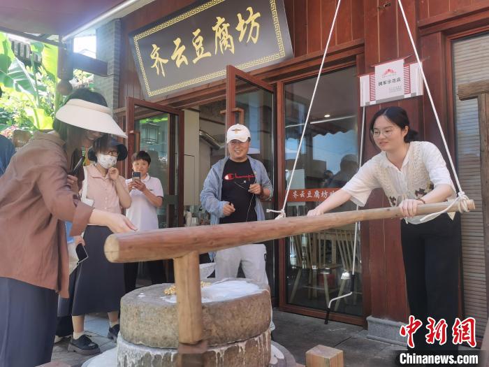 游客体验豆腐制作技艺。 张强 摄 游客体验豆腐制作技艺。 张强 摄